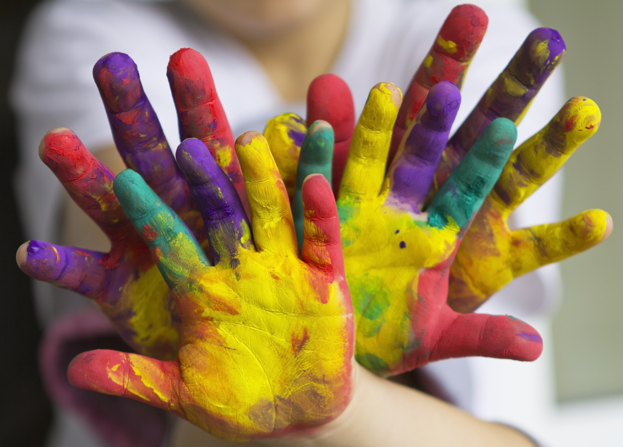 Farbig bemalte Hände in ganz verschiedenen bunten Farben